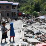 5bb5b793b3bc4-dua-anak-bermain-di-antara-reruntuhan-bangunan-yang-rusak-akibat-gempa-7-4-pada_375_211