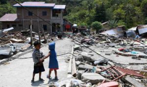 5bb5b793b3bc4-dua-anak-bermain-di-antara-reruntuhan-bangunan-yang-rusak-akibat-gempa-7-4-pada_375_211