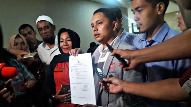 Kuasa hukum Kivlan Zen menunjukkan surat laporan yang telah diterima oleh Bareskrim Polri.