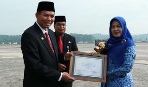 Wali Kota Pekanbaru, Firdaus didampingi Kadis Pendidikan menyerahkan Piagam Pengharagaan Adiwiyata Nasional Tahun 2018 kepada salah seorang perwakilan sekolah.