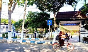 Seorang pelajar melintas di depan SDN Gunung Sekar