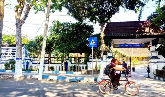 Seorang pelajar melintas di depan SDN Gunung Sekar