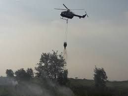 Heli waterboombing melakukan pendinginan area yang terbakar di Riau tahun lalu.